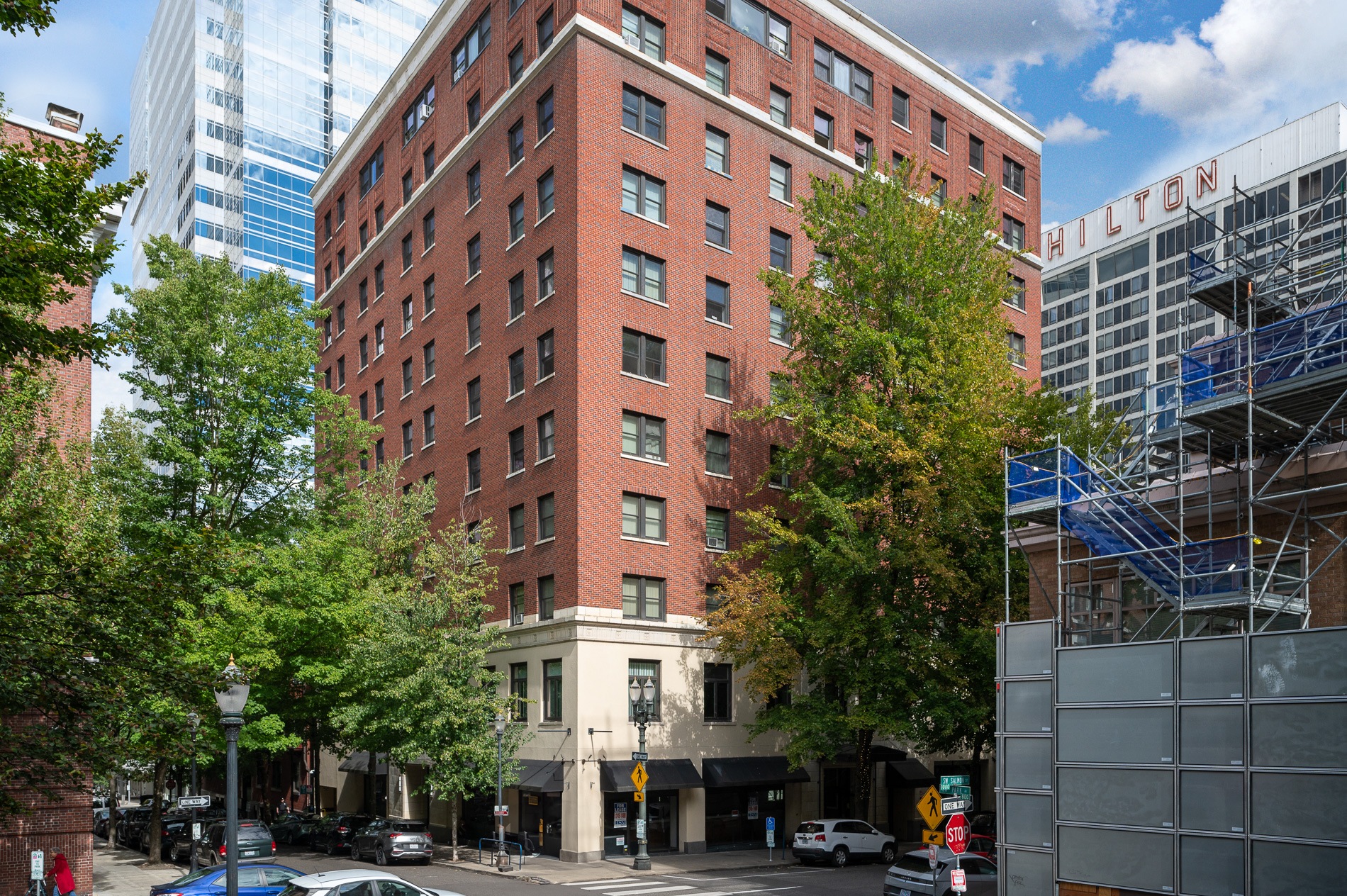 a tall red brick building on the corner of a city street
